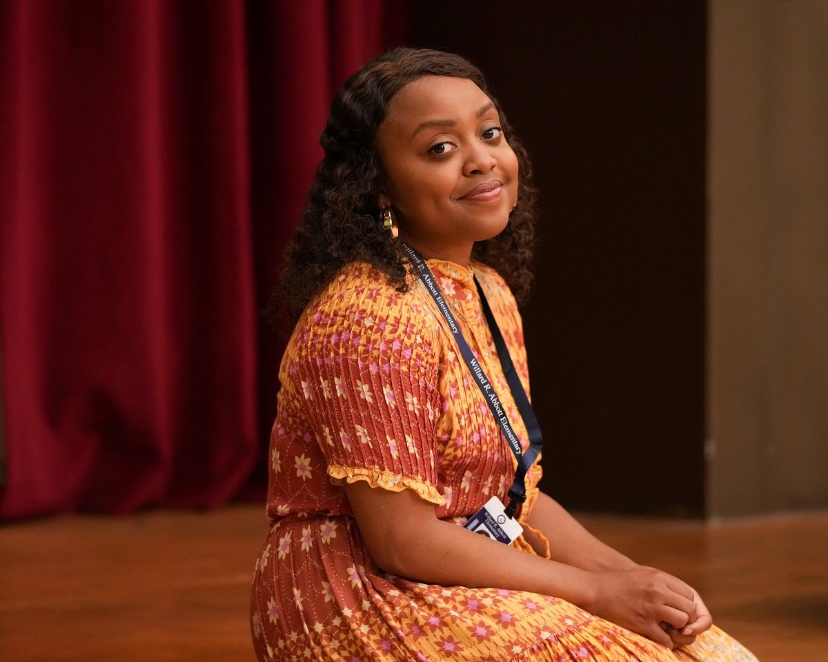 Quinta Brunson as Janine Teagues of Abbott Elementary, wearing an orange floral dress, gives a look to the camera in the mockumentary style that shows like Abbott Elementary also use.