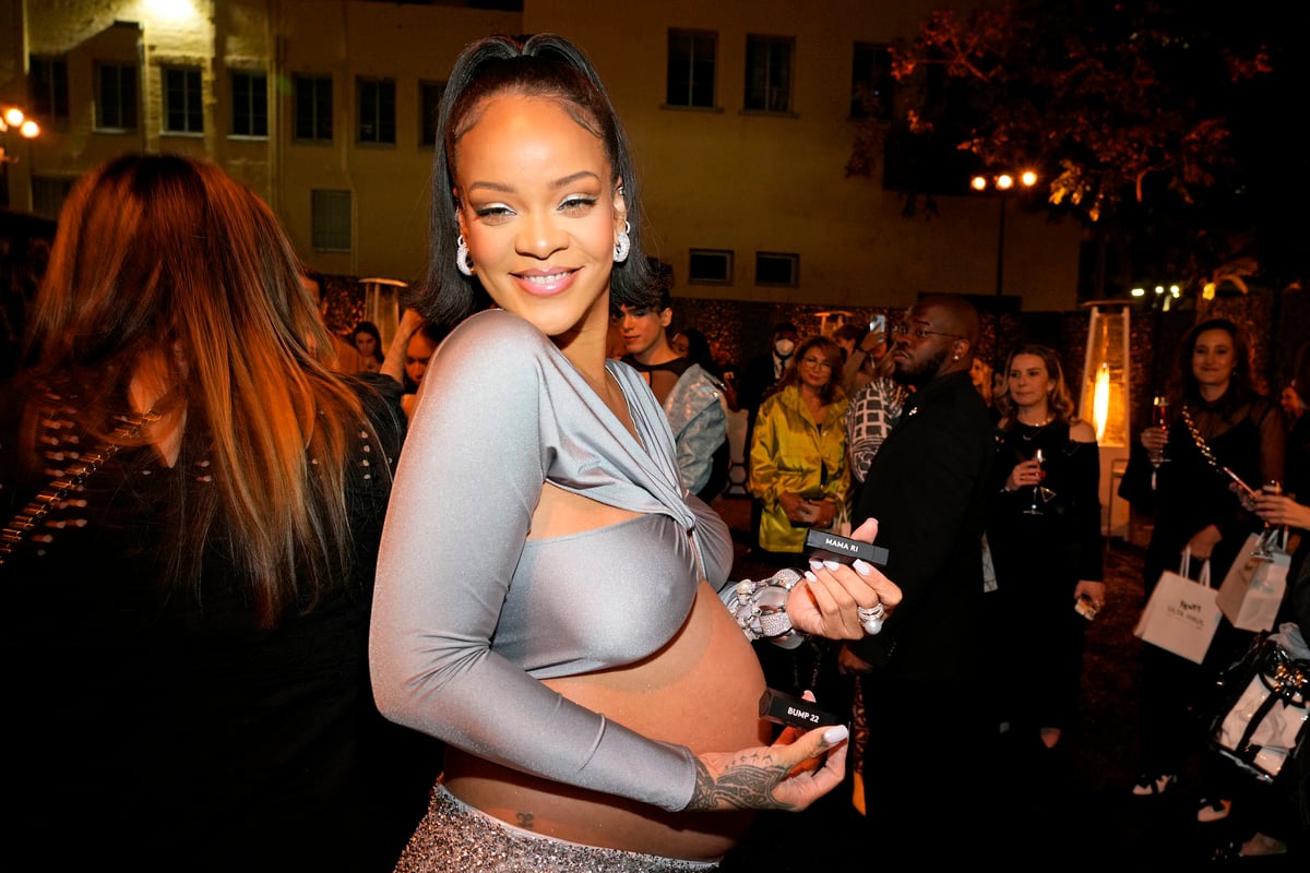 Rihanna smiles with an exposed belly bump at an appears at Ulta beauty in Los Angeles, CA.