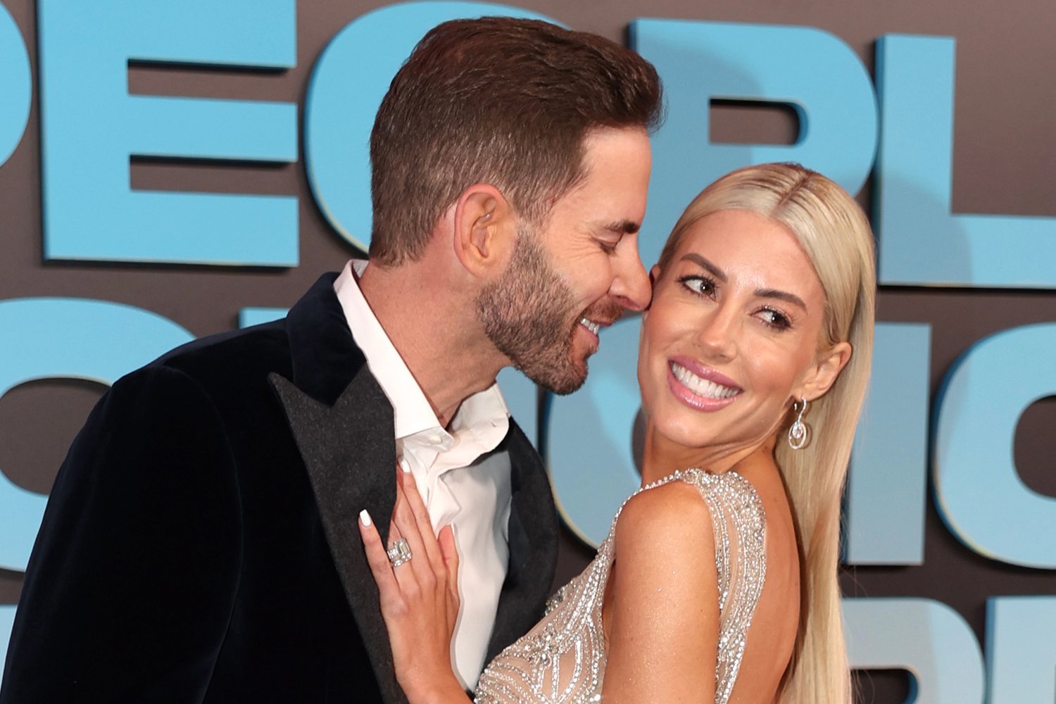 Tarek El Moussa reaches over to wife Heather Rae to kiss her on the cheek