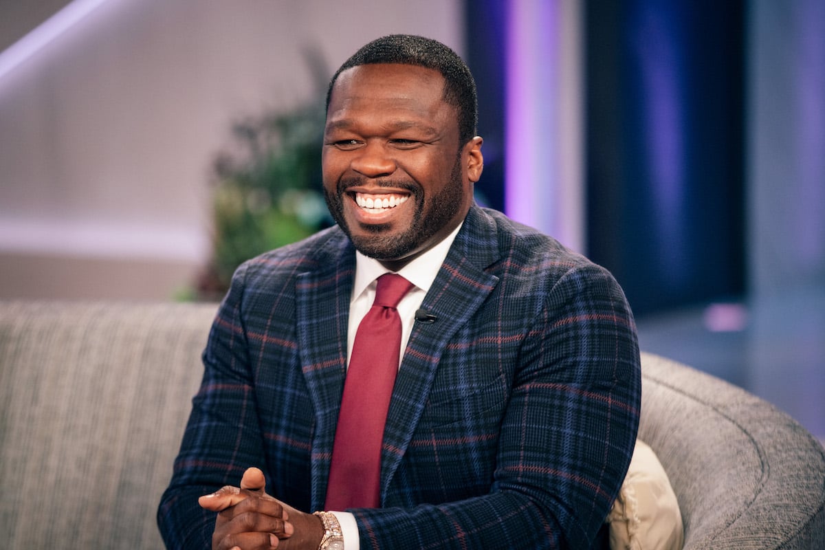 Curtis "50 Cent" Jackson smiling while wearing a blue stripped suit