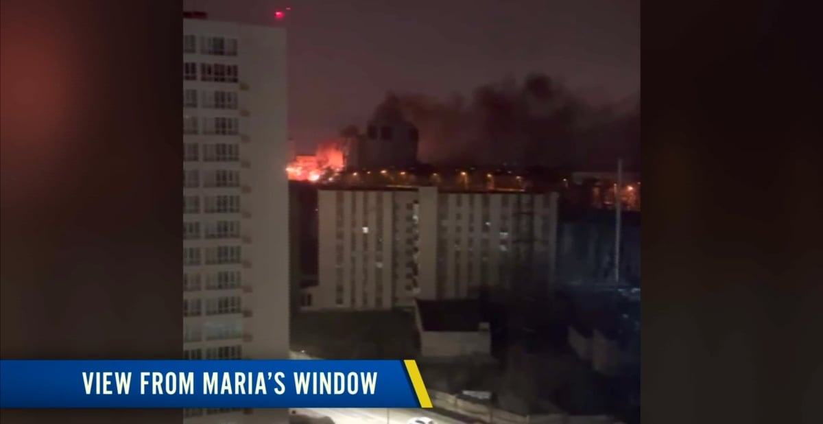 The view outside Maria Divine's apartment, showing explosions and fires behind buildings in Kyiv, Ukraine on '90 Day Diaries'.