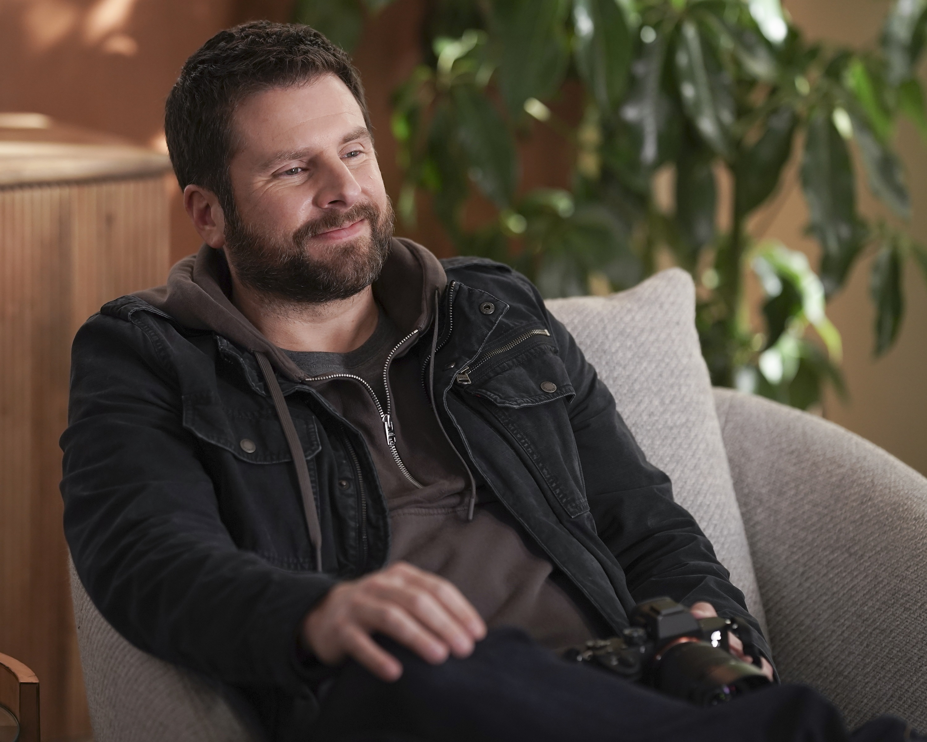 'A Million Little Things' James Roday Rodriguez sitting in a chair smirking as Gary Mendez