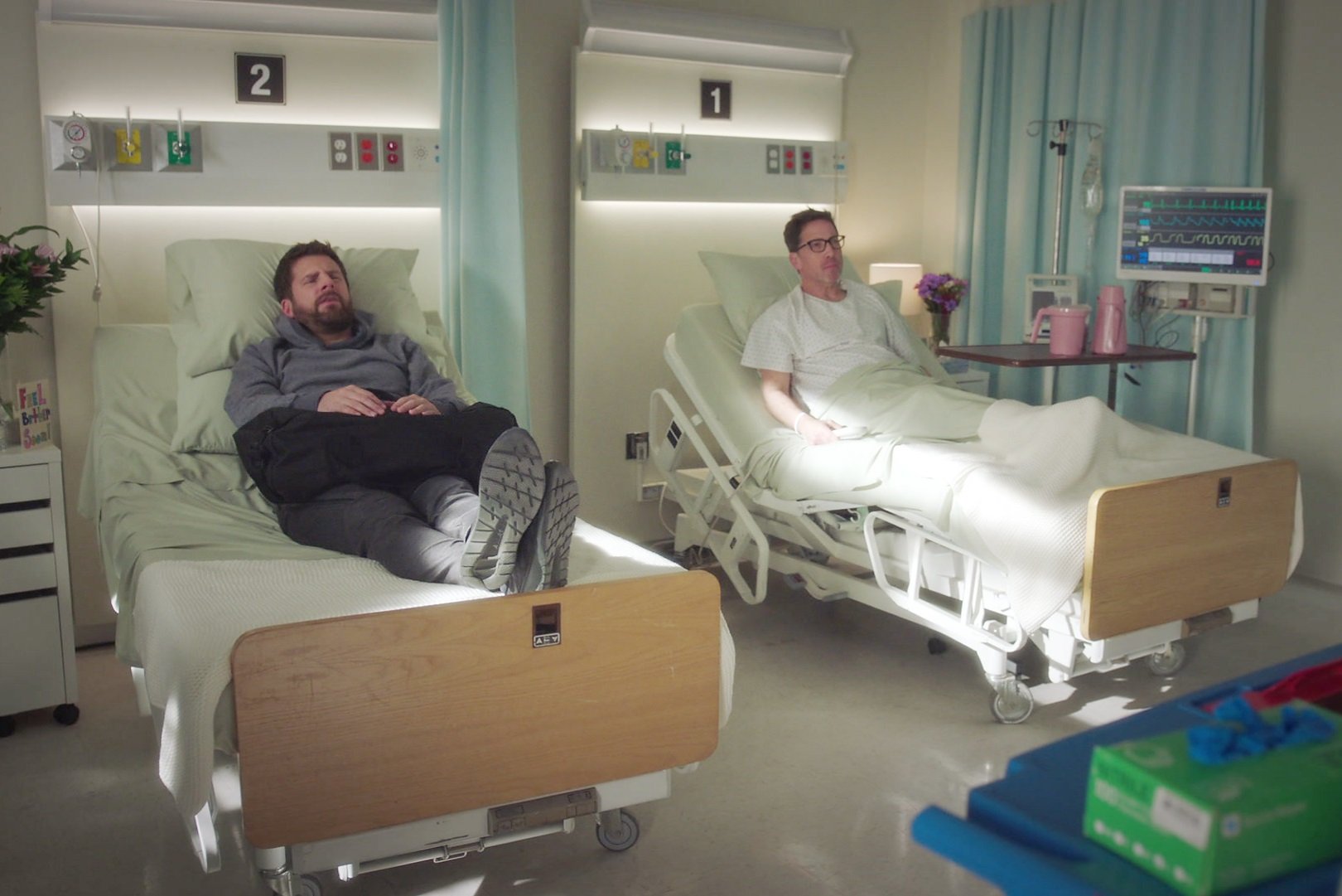 'A Million Little Things' James Roday Rodriguez and Dan Bucatinsky in hospital beds next to each other as Gary and Harrison