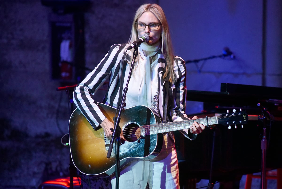 Wearing glasses and a striped blazer Aimee Mann performs on stage at the Mountain Winery in Saratoga, CA.
