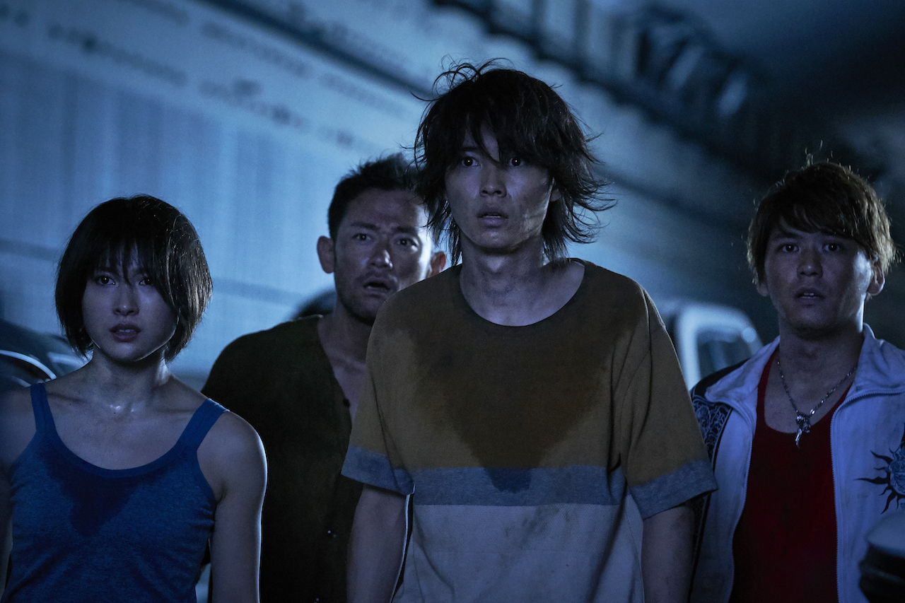 Tao Tsuchiya and Kento Yamazaki look onward in horror in Alice in Borderland Season 1, Episode 1.