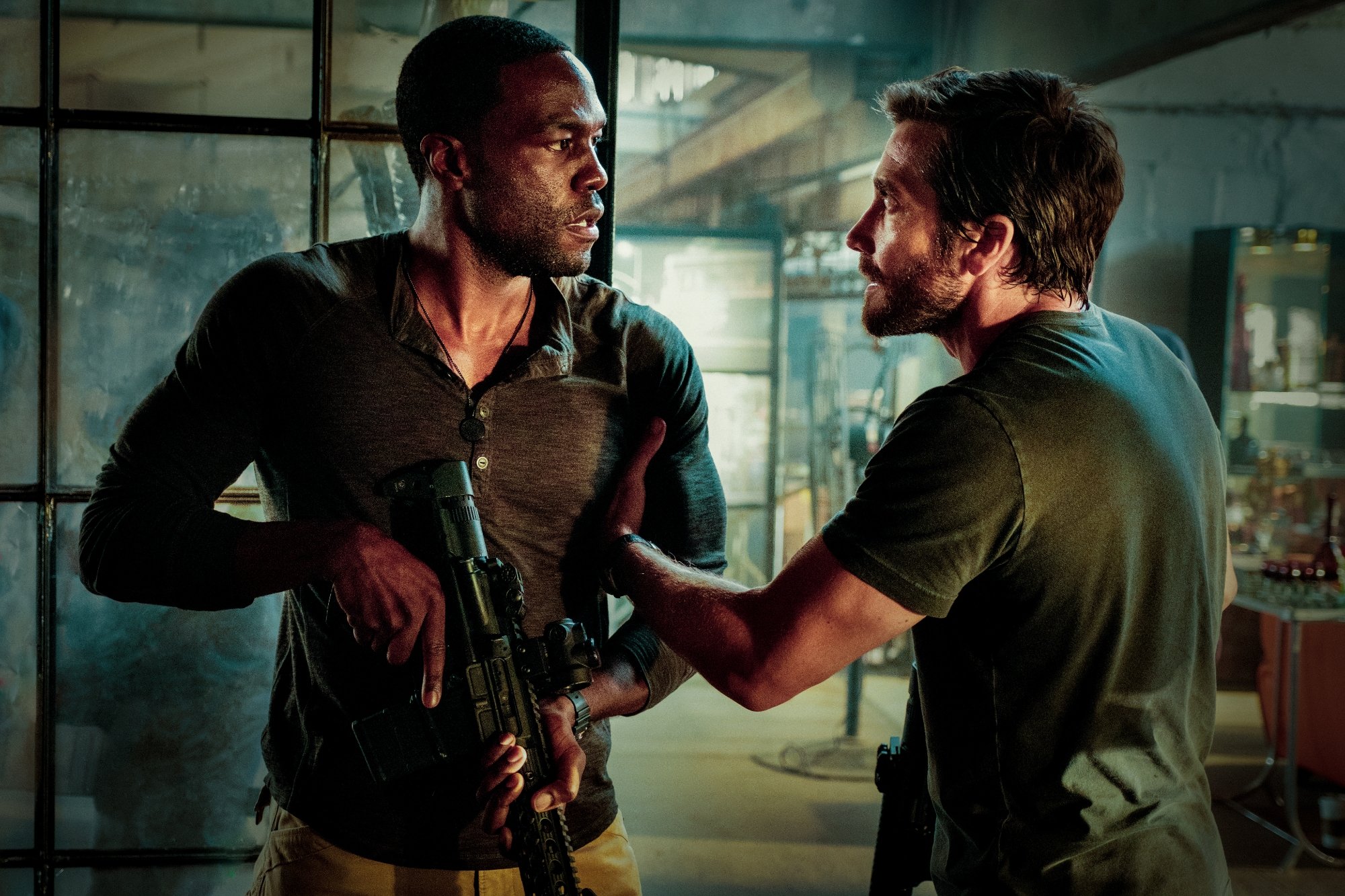 'Ambulance' Yahya Abdul-Mateen II as Will Sharp and Jake Gyllenhaal as Danny Sharp facing each other with Yahya holding a gun