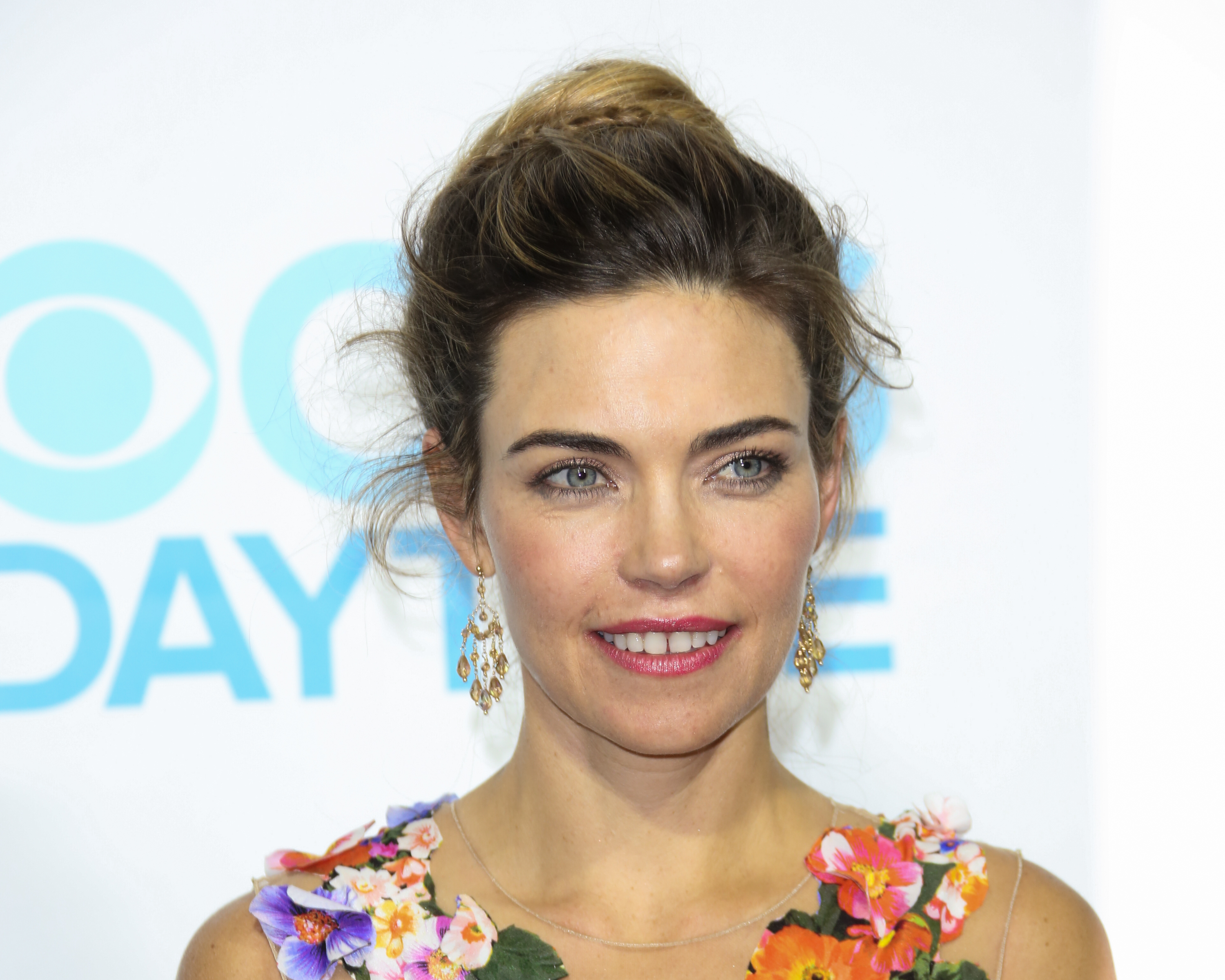 'The Young and the Restless' actor Amelia Heinle wearing an orange floral dress, and her hair in an updo.