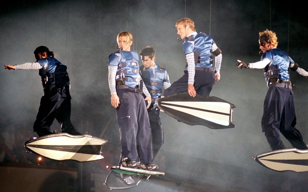 Hanging from harnesses, the Backstreet Boys perform on their tour 
