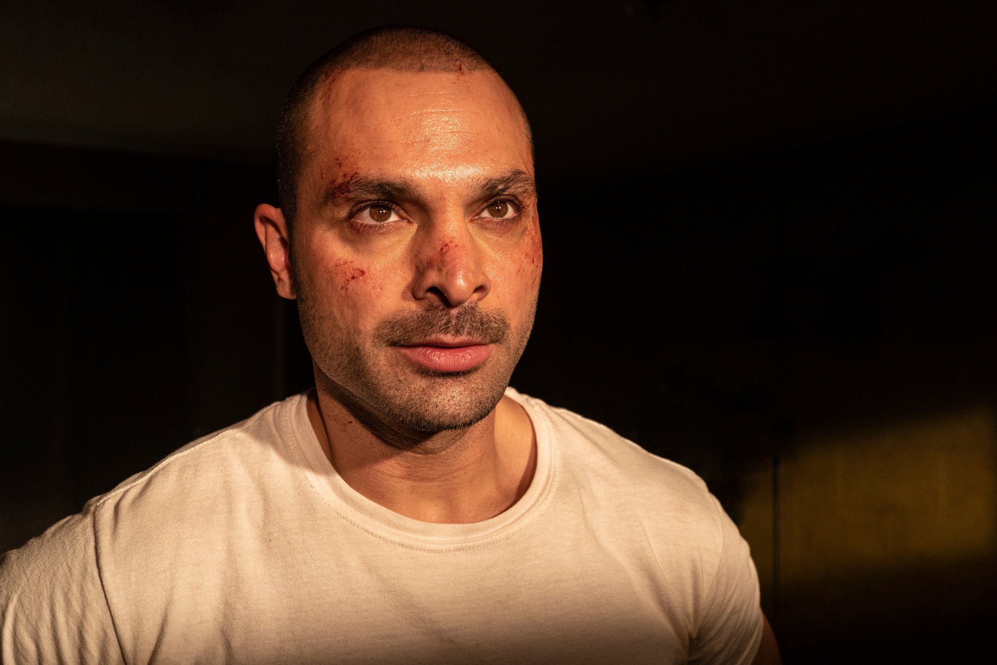 Michael Mando as Nacho Varga in 'Better Call Saul' Season 6. He's wearing a white T-shirt and has cuts on his face.