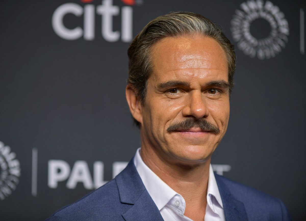 Tony Dalton attends the 39th annual PaleyFest LA - Better Call Saul. He is wearing a button-down shirt and blue suit jacket and has a mustache. 