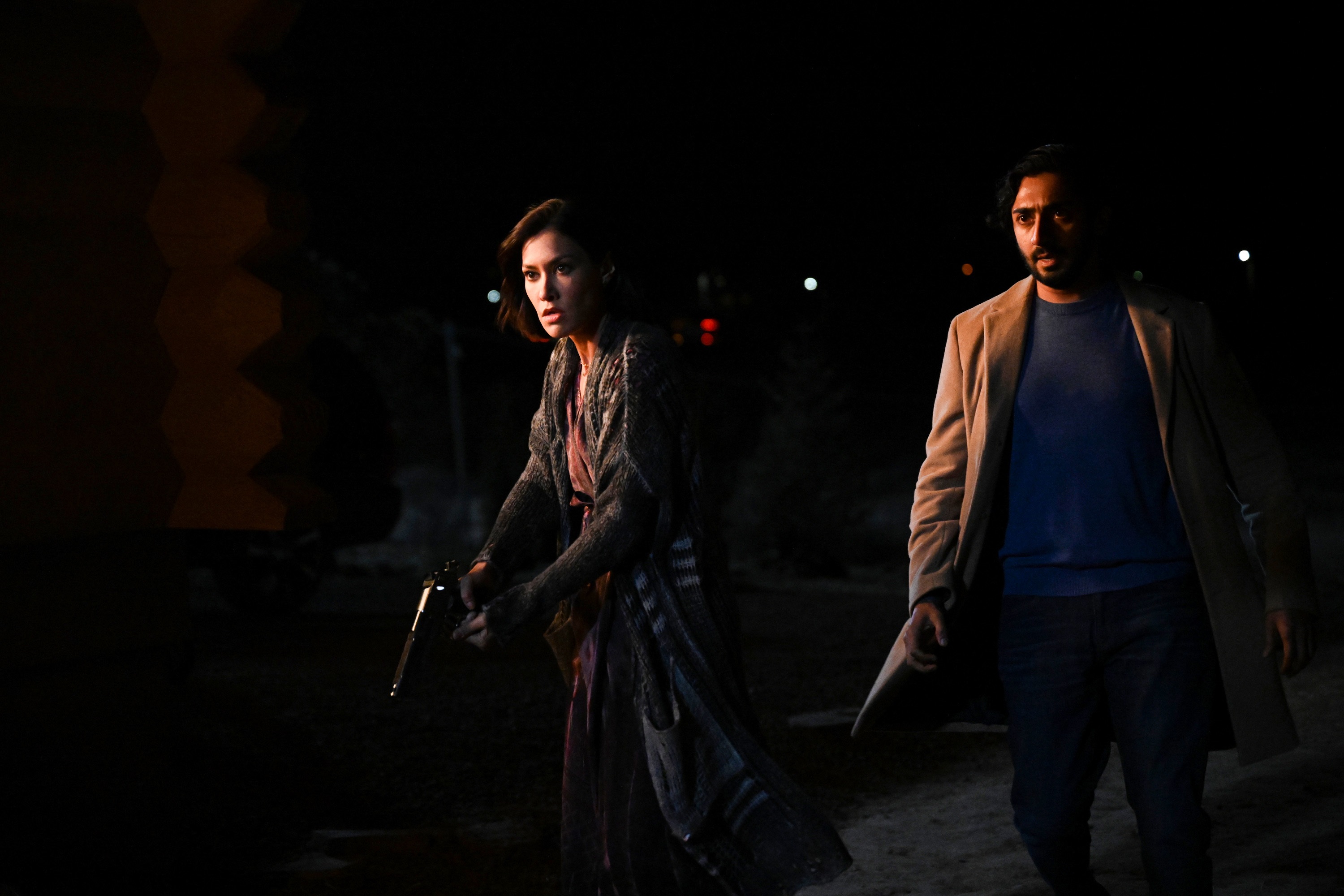 Big Sky cast members Janina Gavankar and Vinny Chhibber looking at something in the dark as Ren and Jag