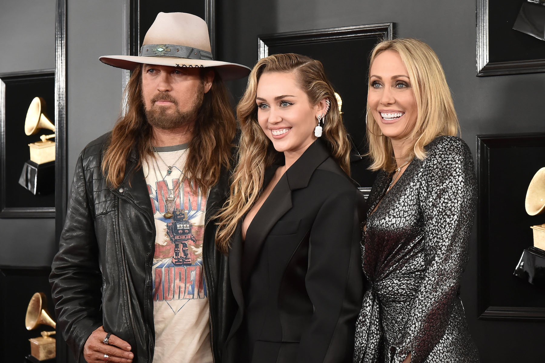 Miley Cyrus' parents, Billy Ray Cyrus and Tish Cyrus, smiling while at an event with her