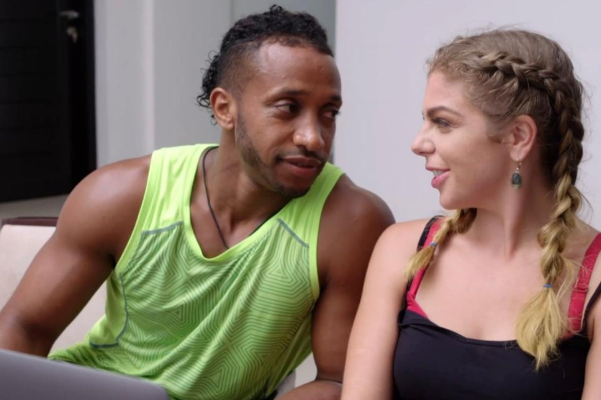 Biniyam Shibre wears a neon green tanktop, sitting next to Ariela Weinberg who is wearing a black tank top on '90 Day Fiancé'.