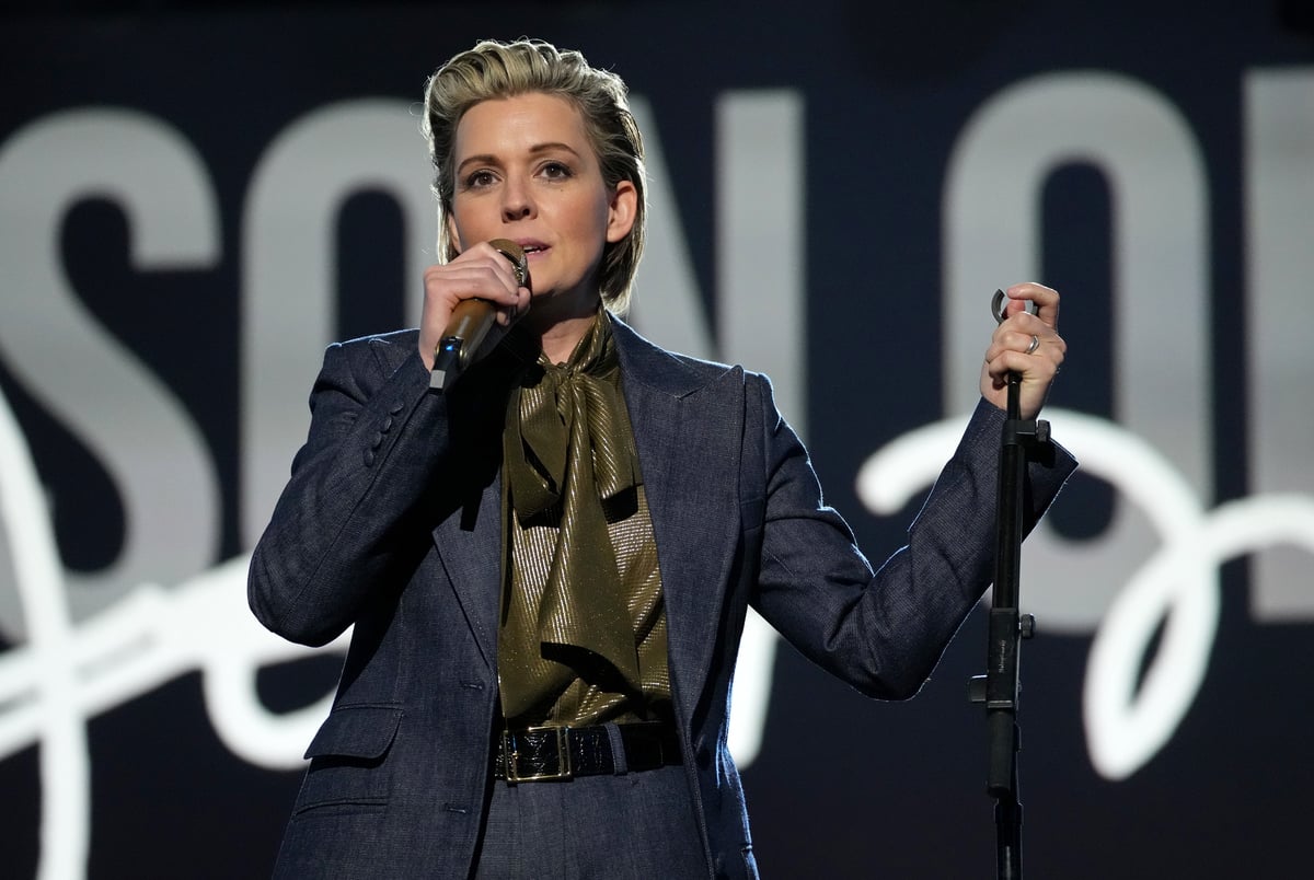 Wearing a dark suit and green shirt, Brandi Carlile performs on stage at the MGM Ballroom in Las Vegas, NV.