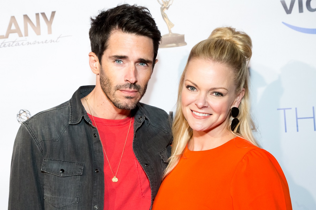 'Days of Our Lives' actor Brandon Beemer in a red shirt and black jacket, and Martha Madison in an orange blouse.