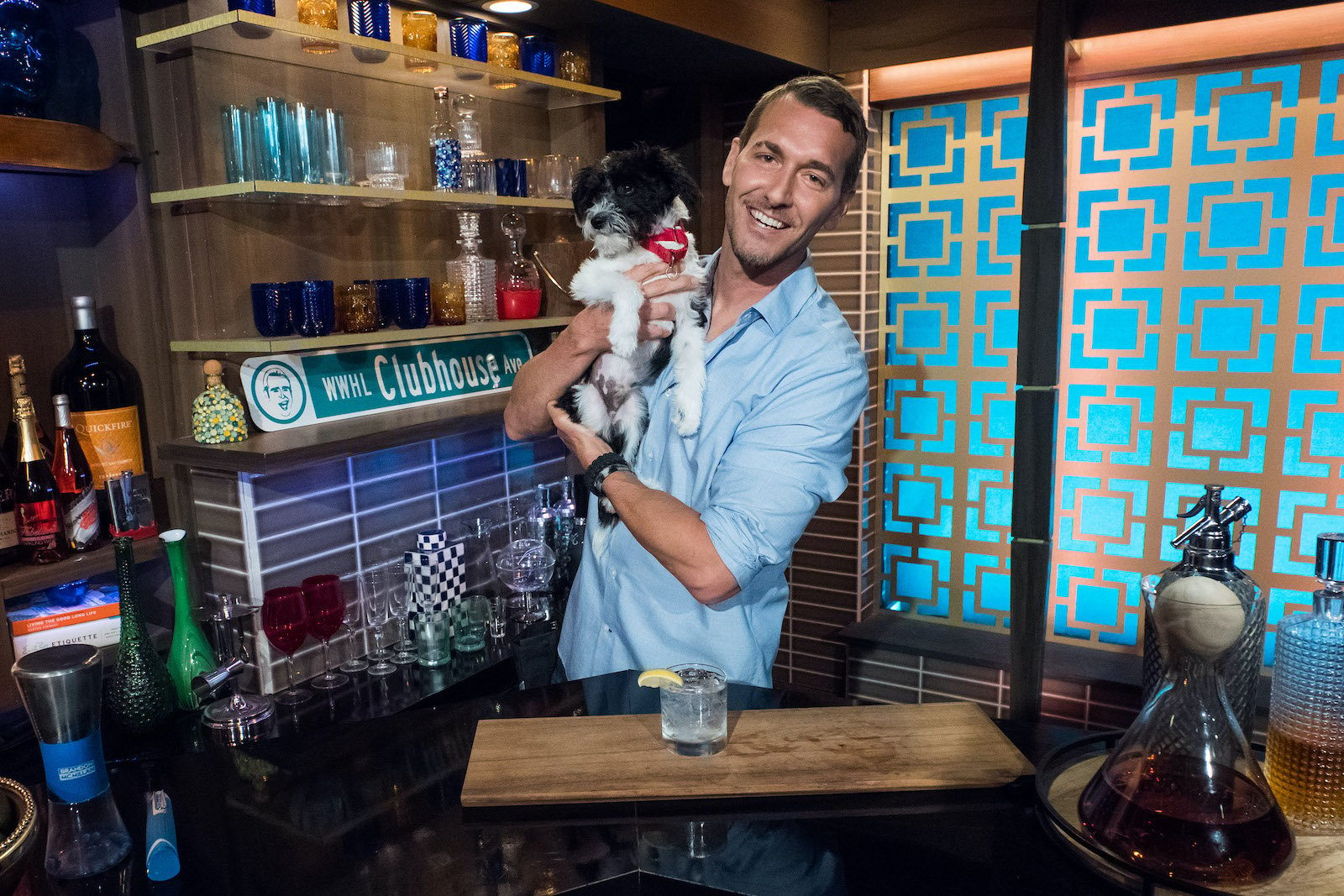 Brandon McMillan snuggles a puppy while bartending on 'WWHL'