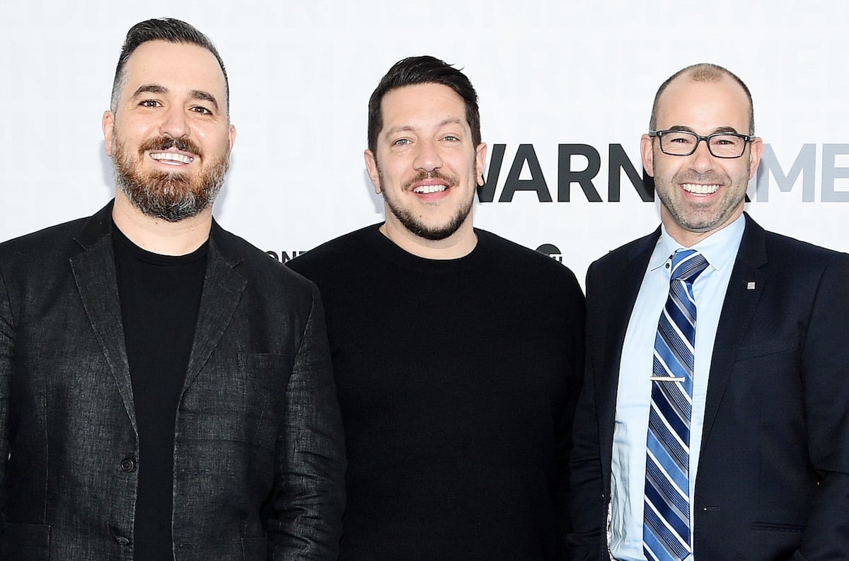 'Impractical Jokers' stars Brian Quinn, Sal Vulcano, and James Murray wear dark suits and pose for a photo at an event for the show