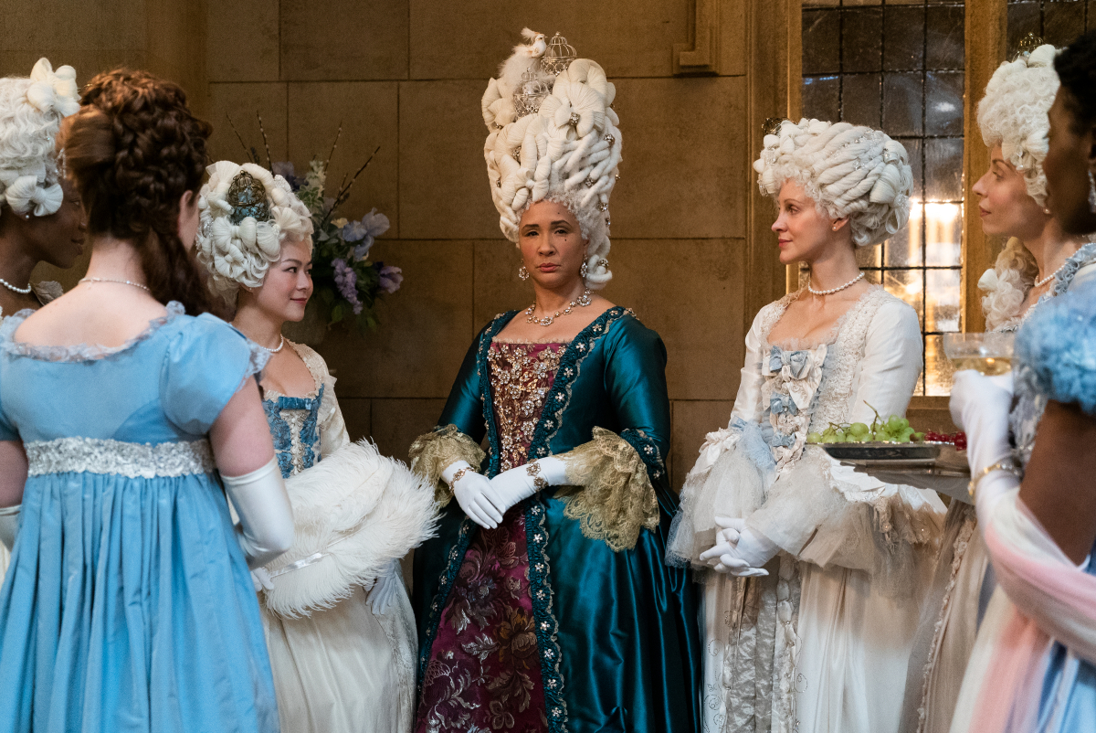 Golda Rosheuvel as Queen Charlotte in Bridgerton Season 2. Charlotte wears a blue and purple dress with a large white wig.  