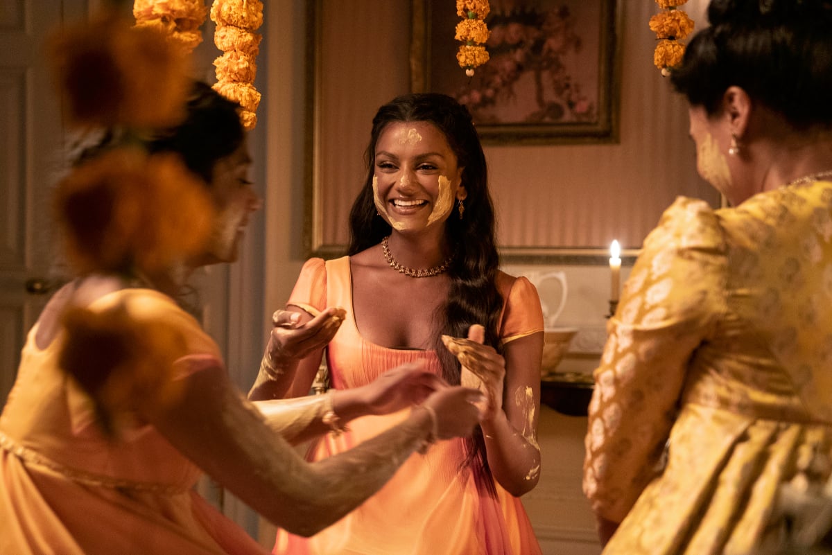Charithra Chandran as Edwina Sharma, Simone Ashley as Kate Sharma, Shelley Conn as Mary Sharma in Bridgerton Season 2. The Sharmas participate in the Haldi ceremony. 