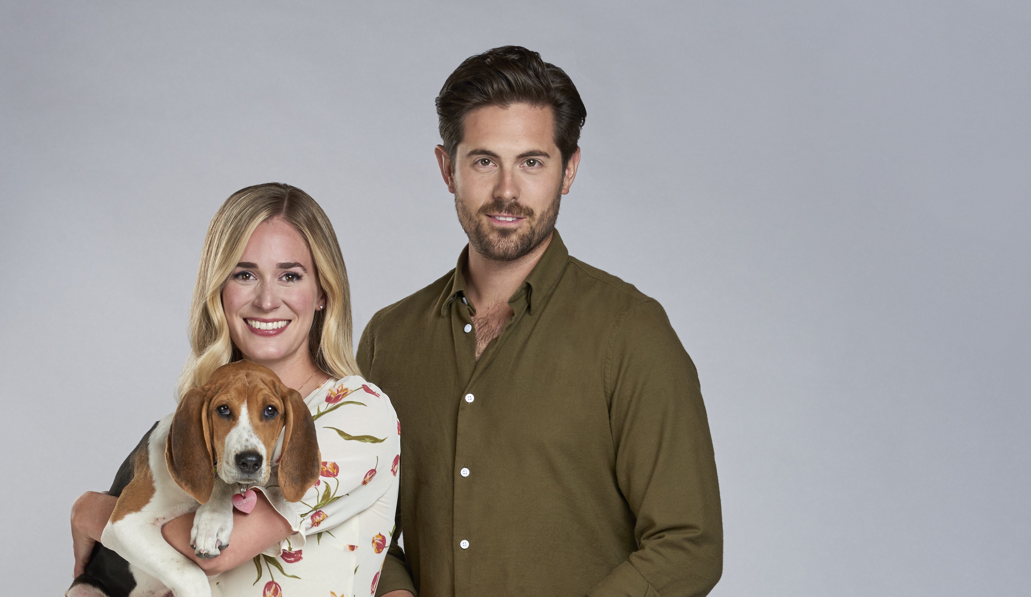 Brittany Bristow, holding a dog, standing next to Chris McNally in promotional image for Hallmark's 'A Tail of Love'