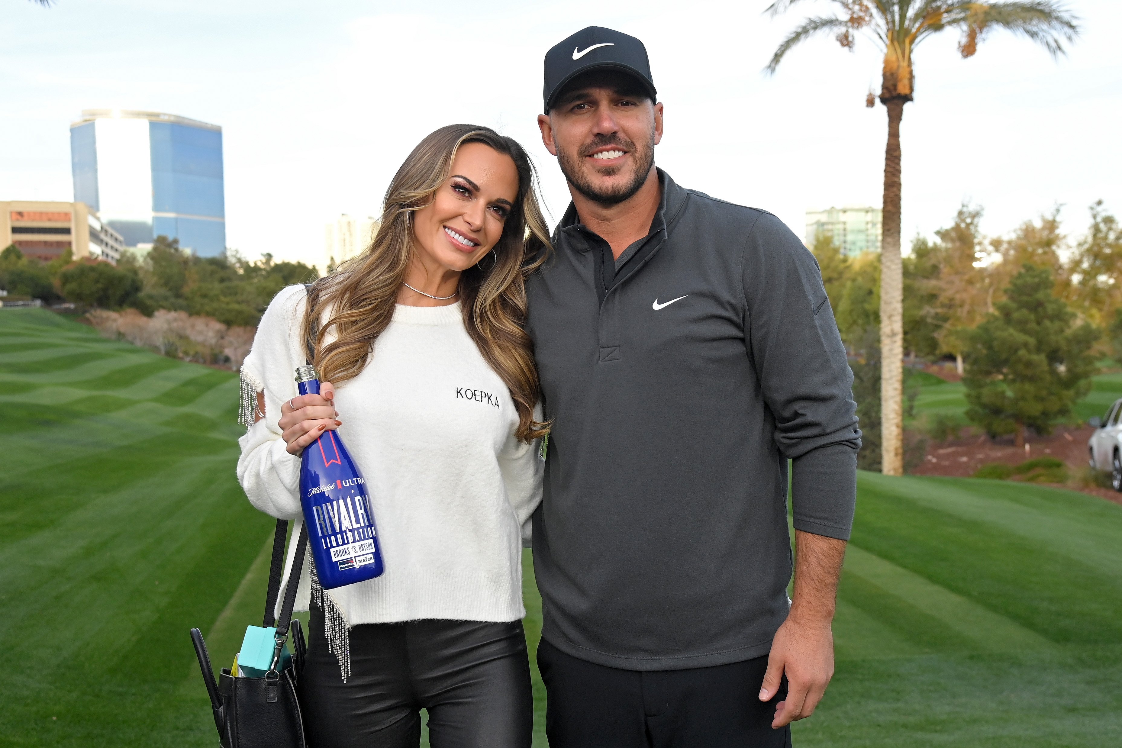 Brooks Koepka and his fiancée Jena Sims pose for photos during Capital One's The Match V Bryson v Brooks
