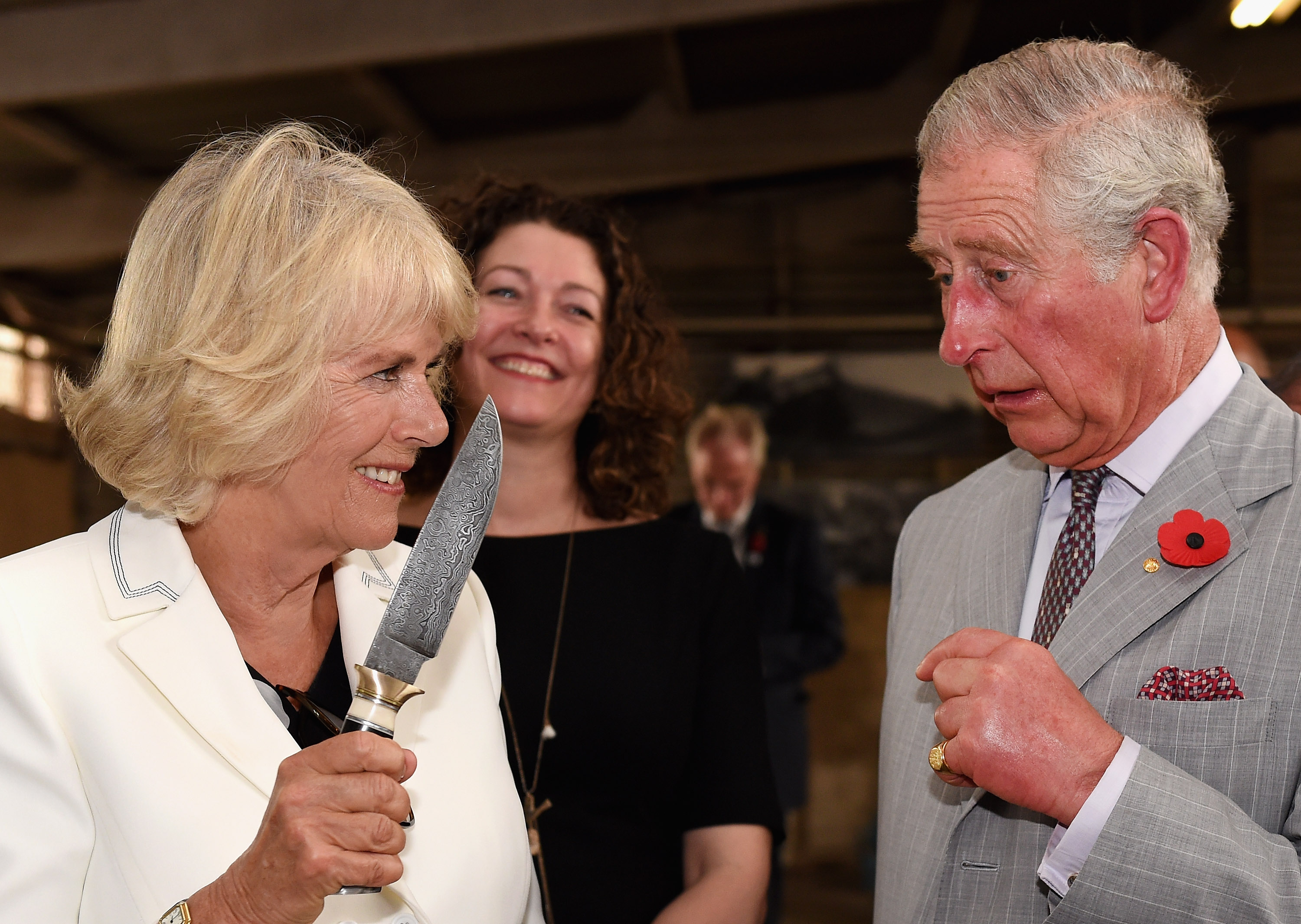 Camilla Parker Bowles holding a knife up in front of Prince Charles during a visit to a winery in Australia
