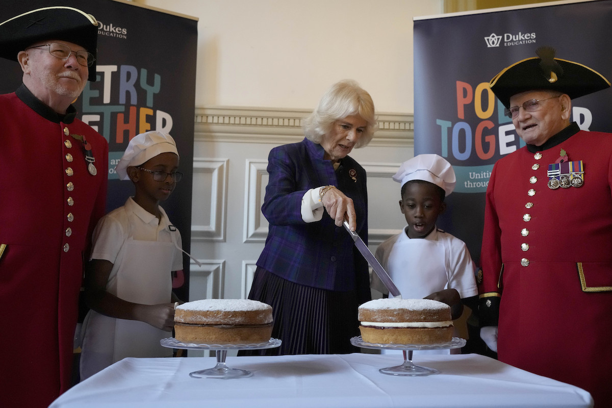 Camilla Parker Bowles slices Victoria Sponge Cakes while the kids look on