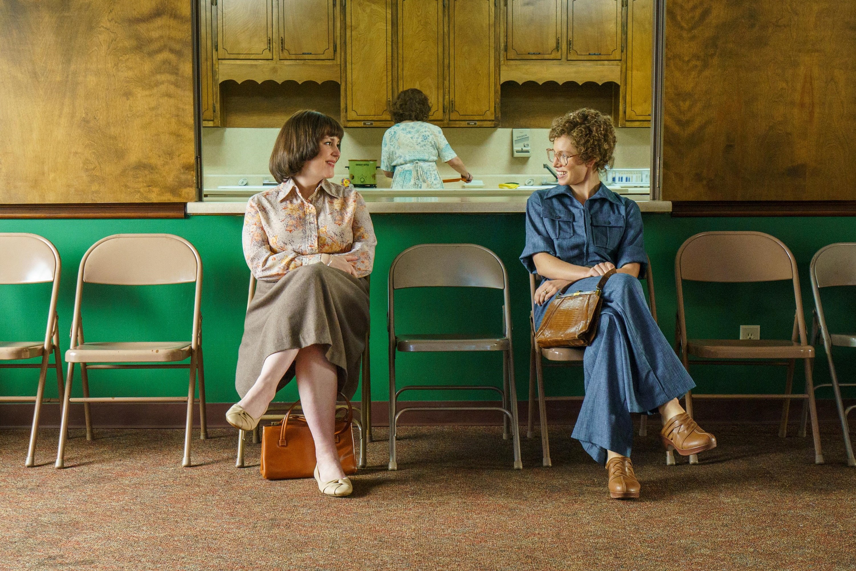 'Candy' cast members Melanie Lynskey and Jessica Biel sit in folding chairs looking at each other as Betty Gore and Candy Montgomery