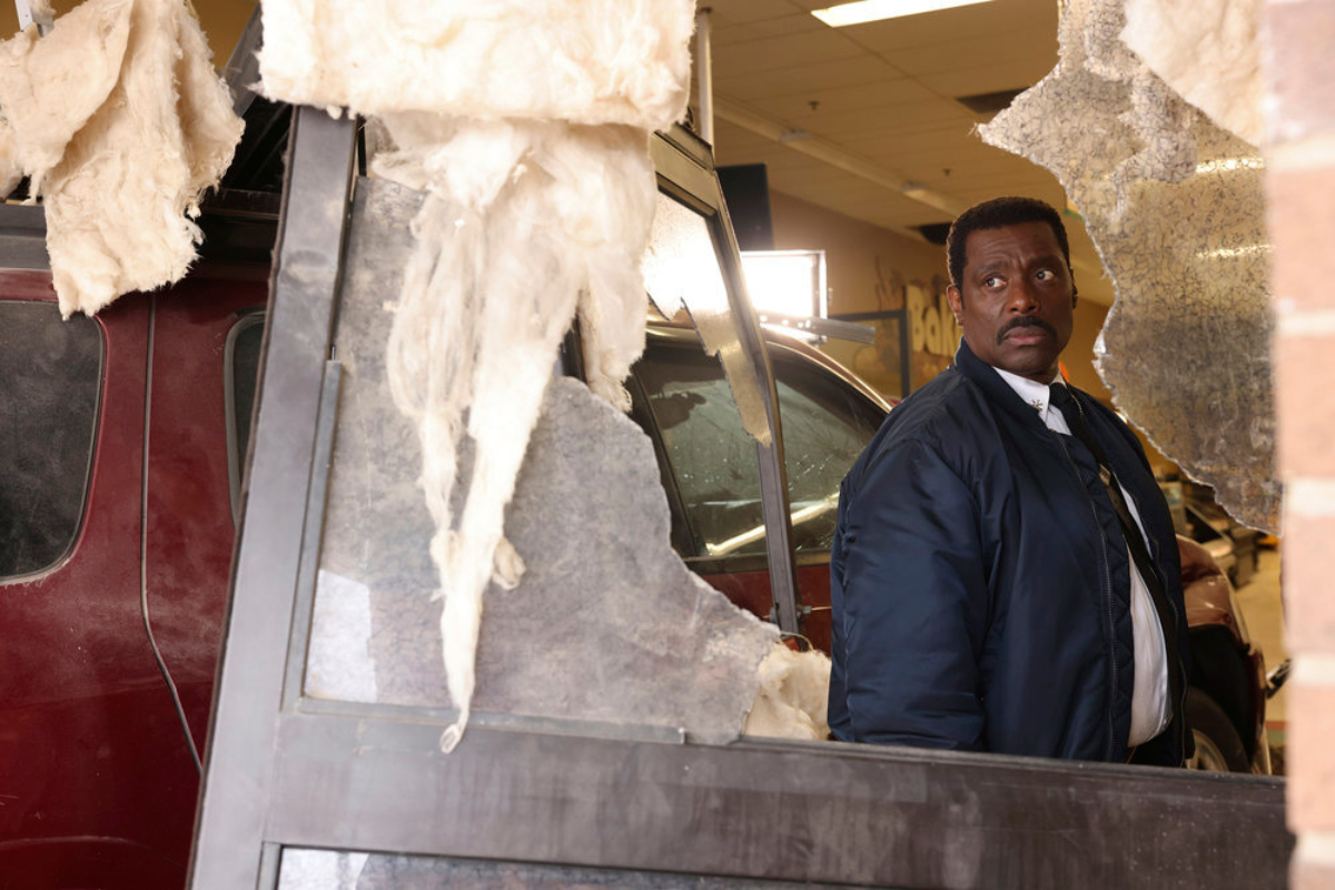 Eamonn Walker as Wallace Boden in Chicago Fire Season 10. Boden looks through a broken window.  