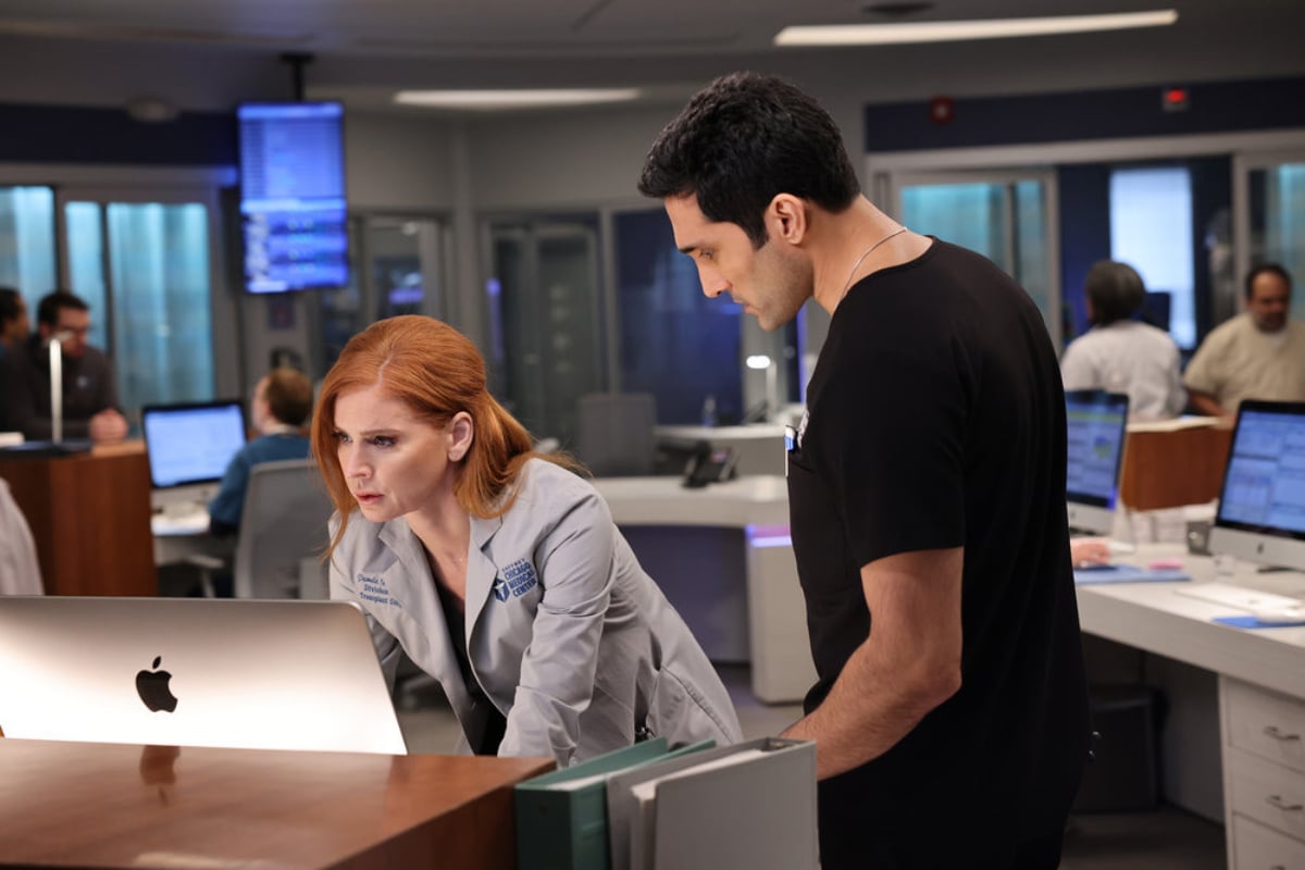 Sarah Rafferty as Dr. Pamela Blake and Dominic Rains as Dr. Crockett Marcel  in Chicago Med Season 7. The doctors look at a computer screen. 