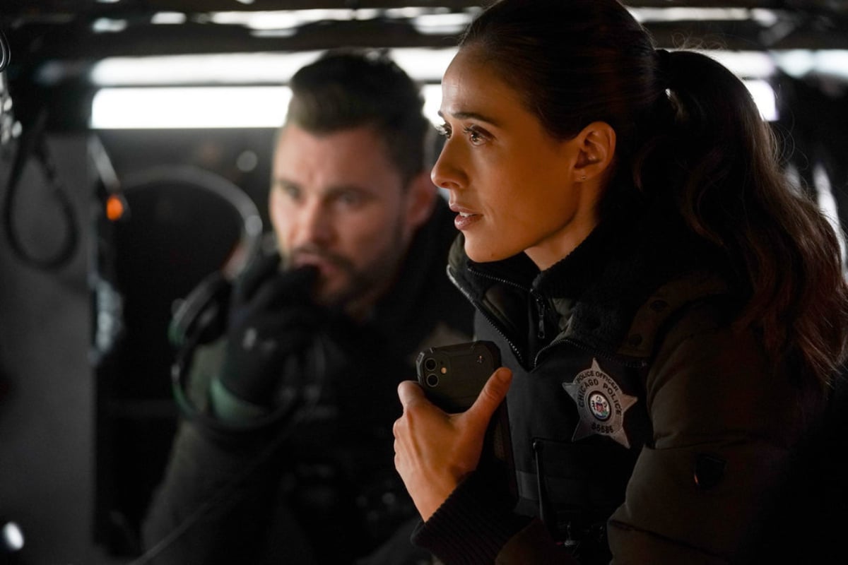 Patrick John Flueger as Adam Ruzek and Marina Squerciati as Kim Burgess in Chicago P.D. Season 9. Burgess and Ruzek wait in a van. 