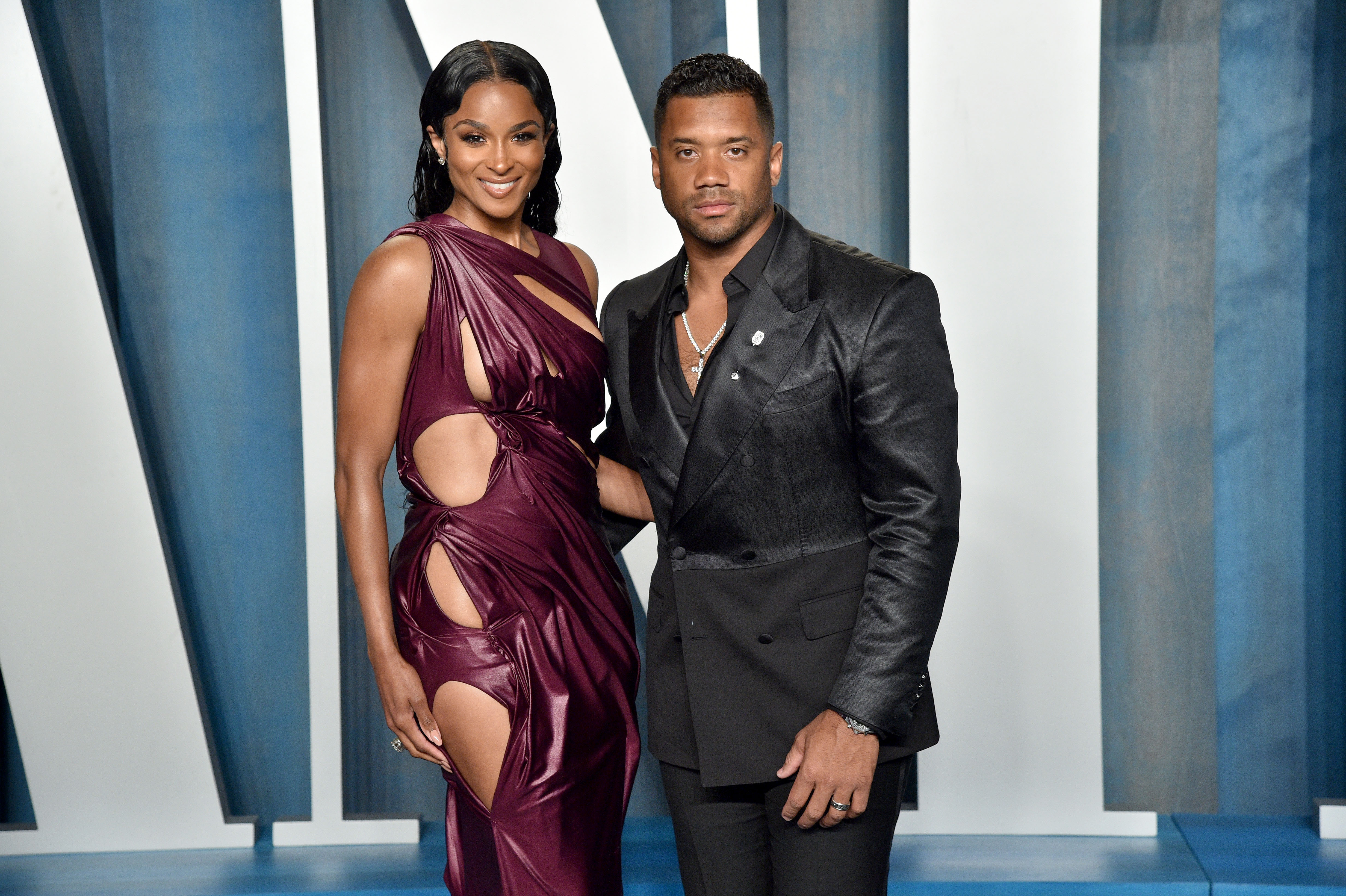 Ciara and Russell Wilson smile while posing on the red carpet.