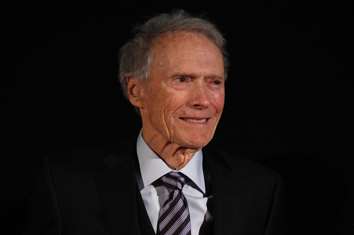 Clint Eastwood smiling while wearing a suit.