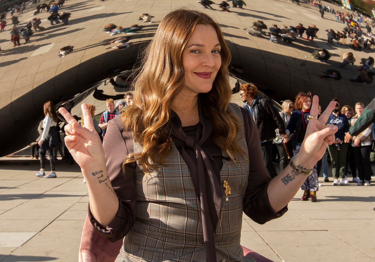 Drew Barrymore makes peace signs with both hands