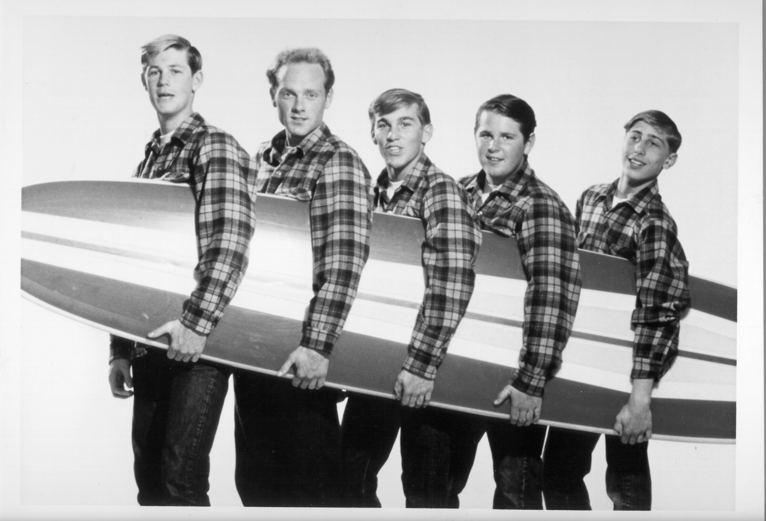 The Beach Boys holding a surf board