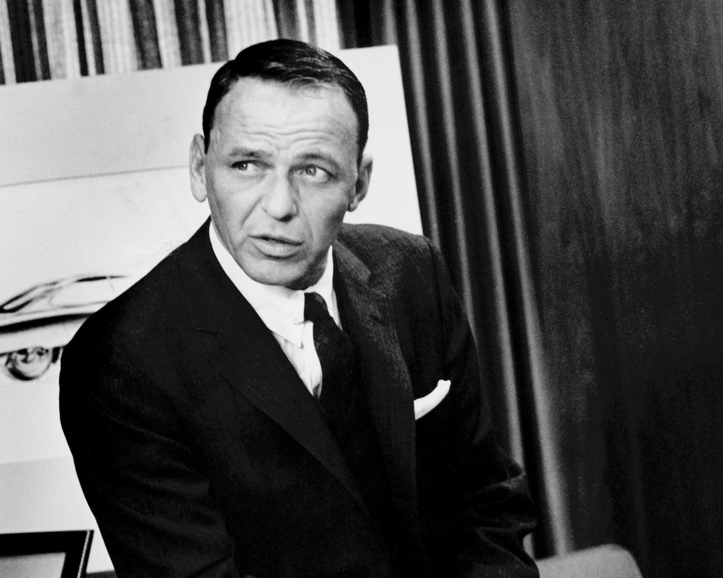 A black and white photo of Frank Sinatra wearing a suit.