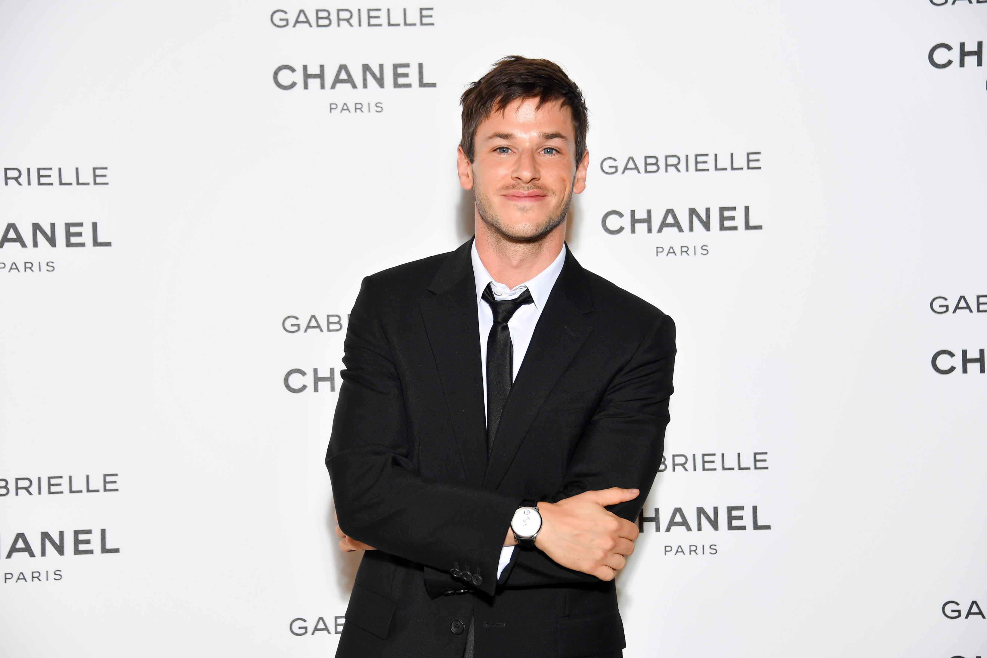 'Moon Knight' star Gaspard Ulliel wears a black suit over a white button-up shirt and black tie.