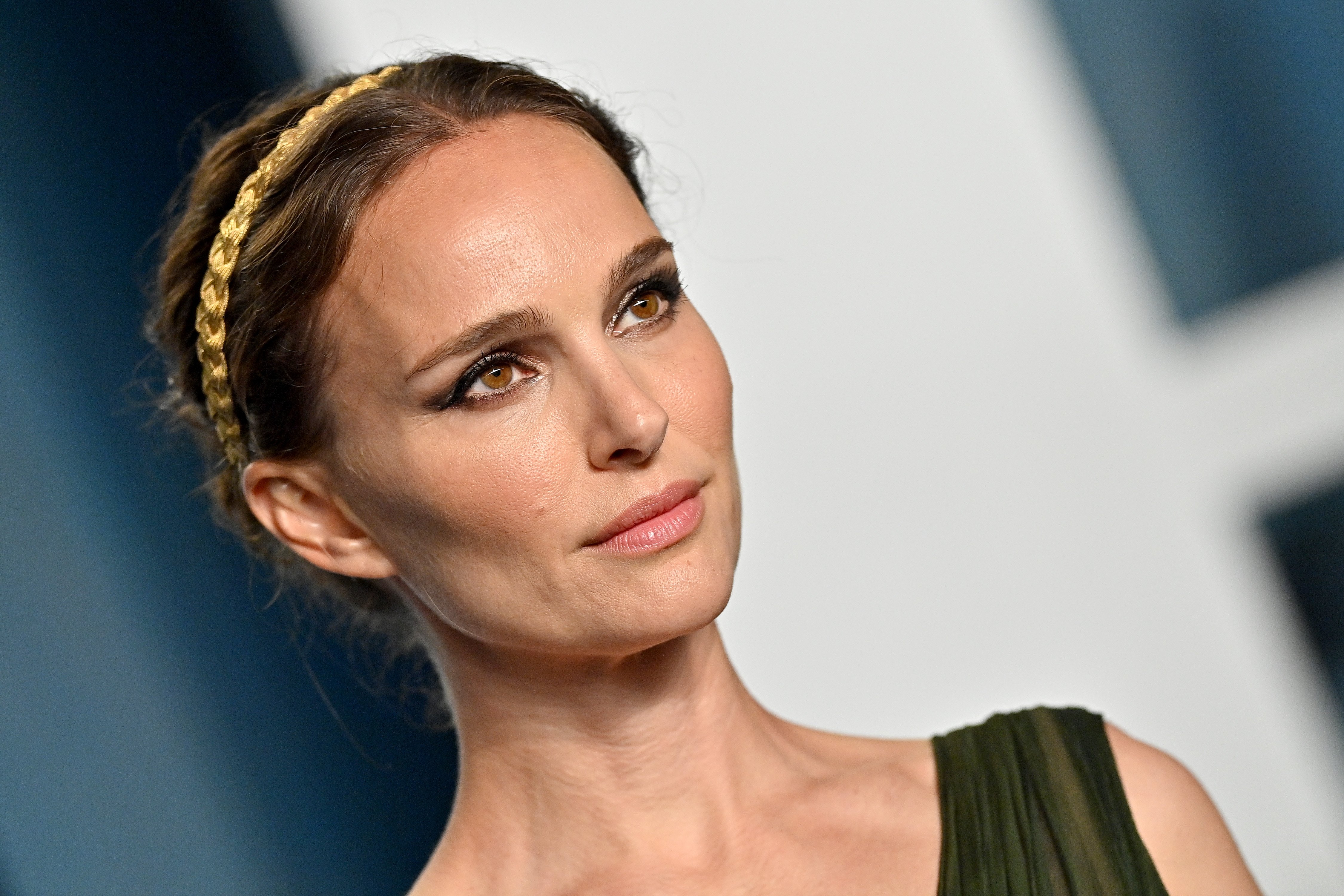 Natalie Portman, who stars in the 'Thor: Love and Thunder' trailer, wears a dark green dress and gold braided headband.