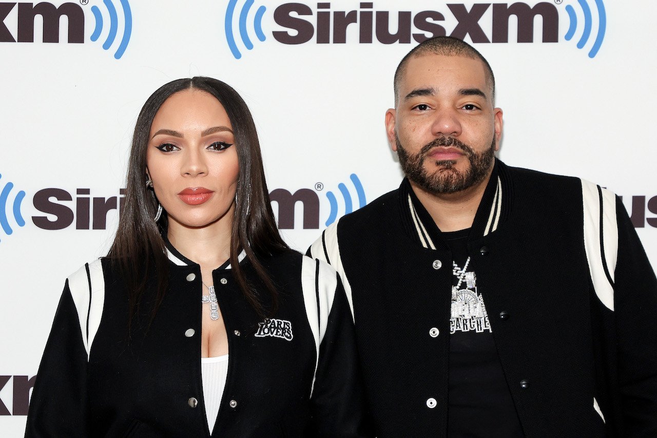 Gia Casey and DJ Envy, who have opened up about Envy's infidelity, pose for photo wearing matching black and white jackets.