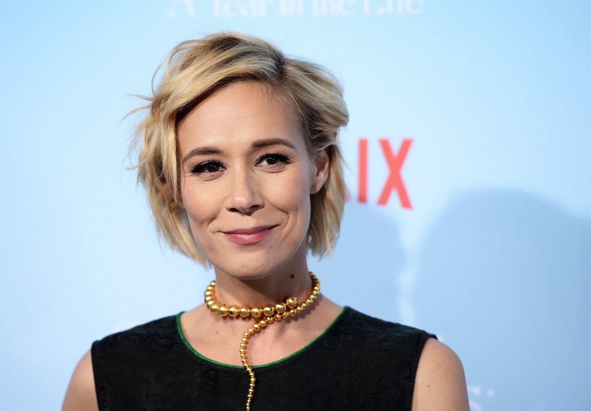 Gilmore Girls Paris Geller actor Liza Weil smiles wearing a black outfit at the premiere of Gilmore Girls: A Year in the Life.