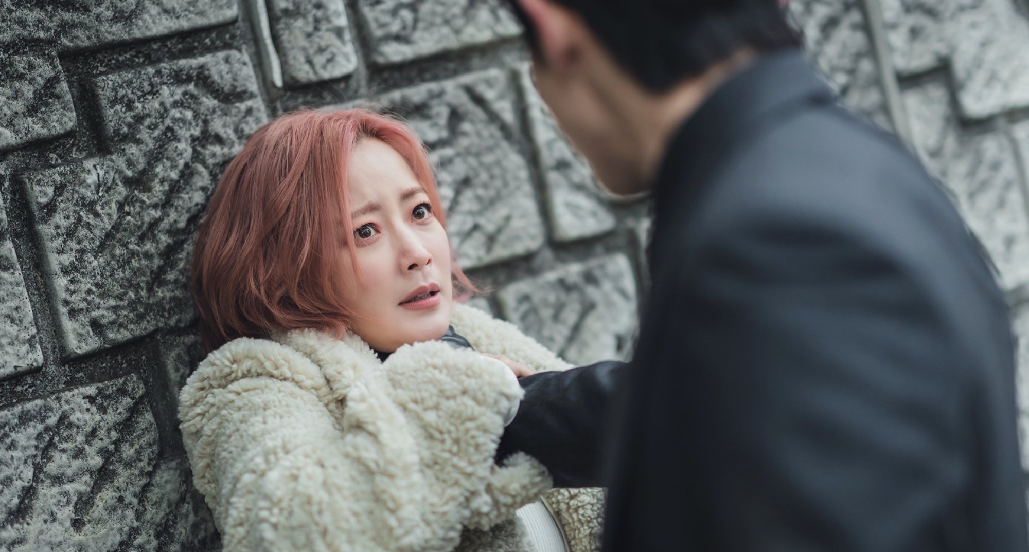 Goo Ryeon and Joong-gil from 'Tomorrow' K-drama against a stone wall.