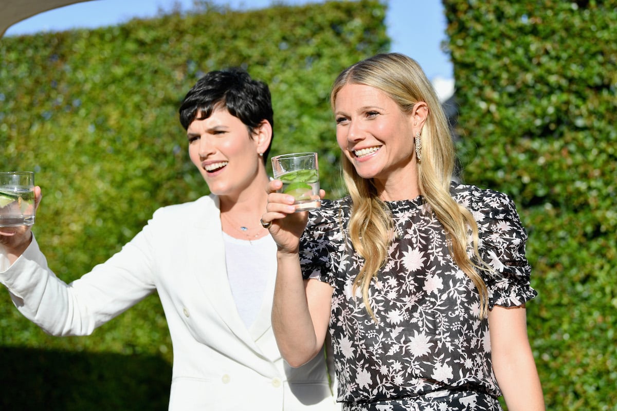 Goop leaders Elise Loehnen (L) and Gwyneth Paltrow hold glasses of water with cucumber in them at the In goop Health Summit at 3Labs in 2018