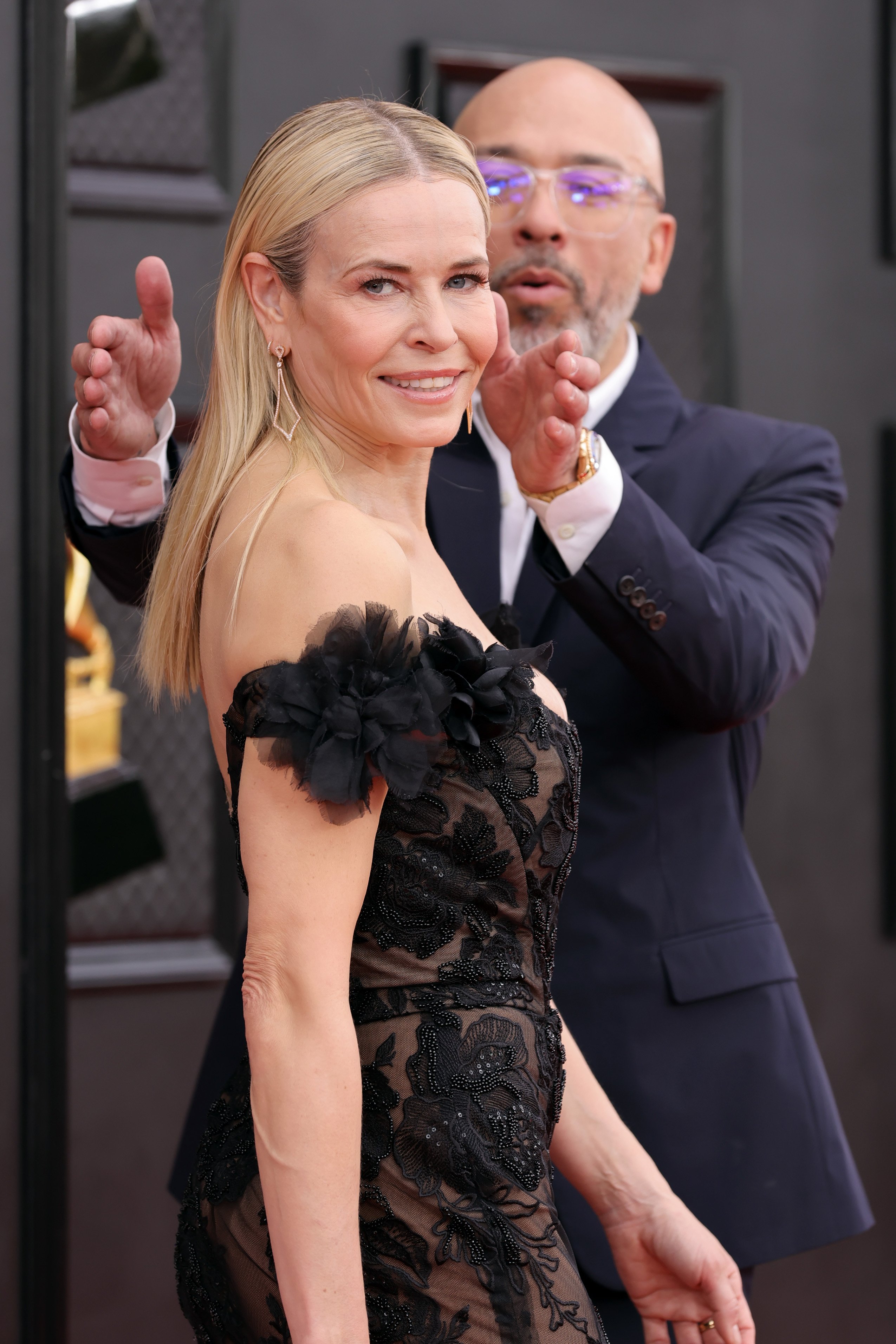 Jo Koy helps girlfriend, Chelsea Handler fix her hair on the red carpet at the Grammy Awards