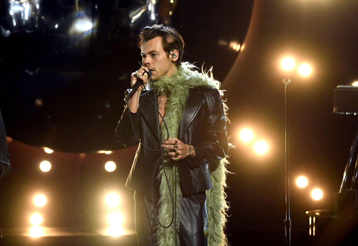 Wearing a black leather suit with a green feather boa wrapped around his neck Harry Styles performs at the 63rd Annual Grammy Awards in LA.