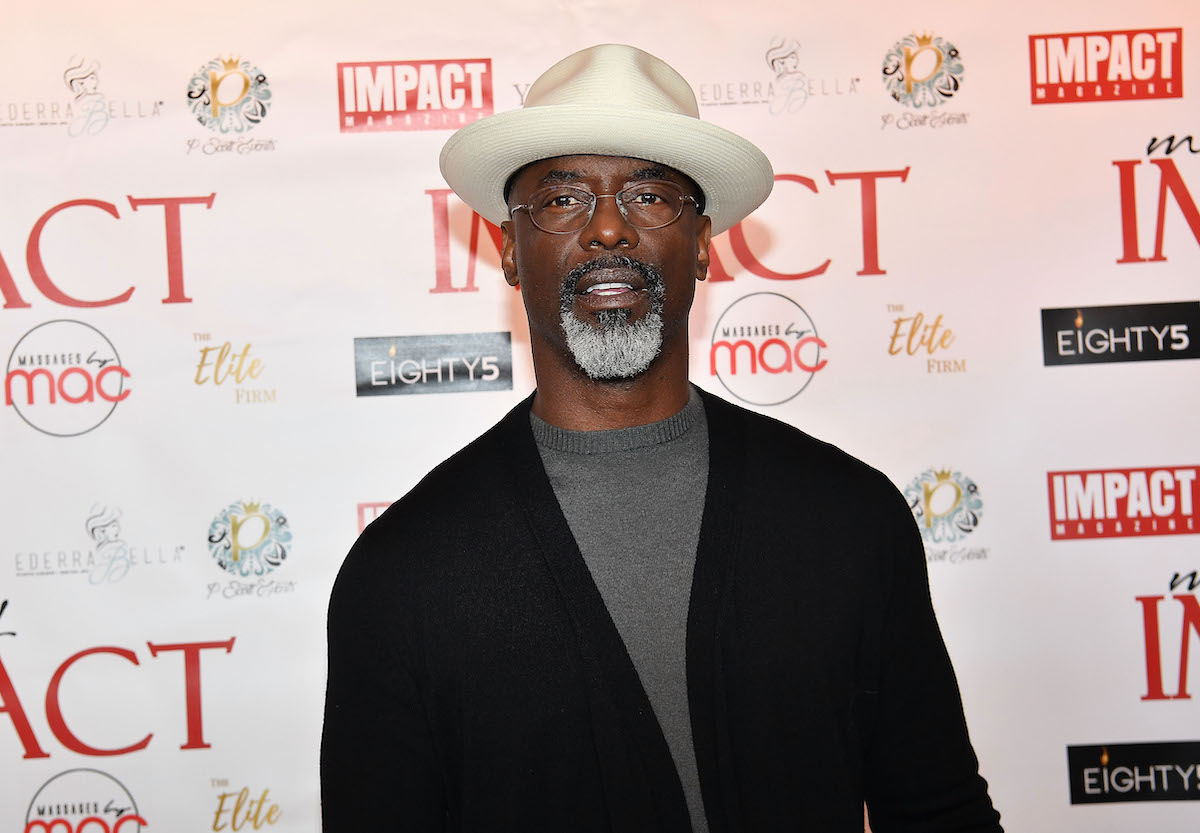 Isaiah Washington of 'P-Valley' poses for a photo at an event, wearing a dark-colored outfit
