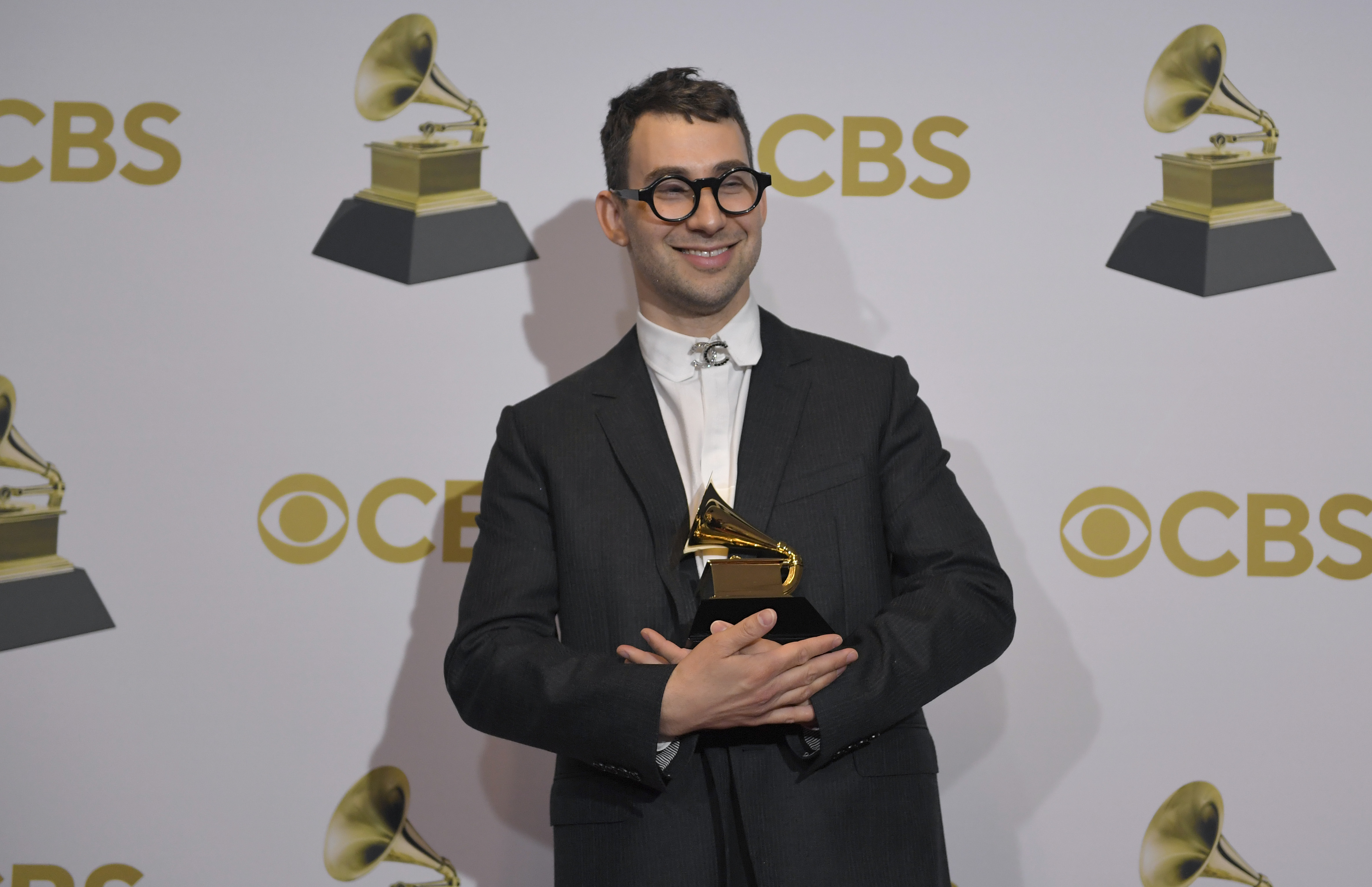 Jack Antonoff holds a Grammy Awards trophy in the winners photo room at the 2022 Grammy Awards
