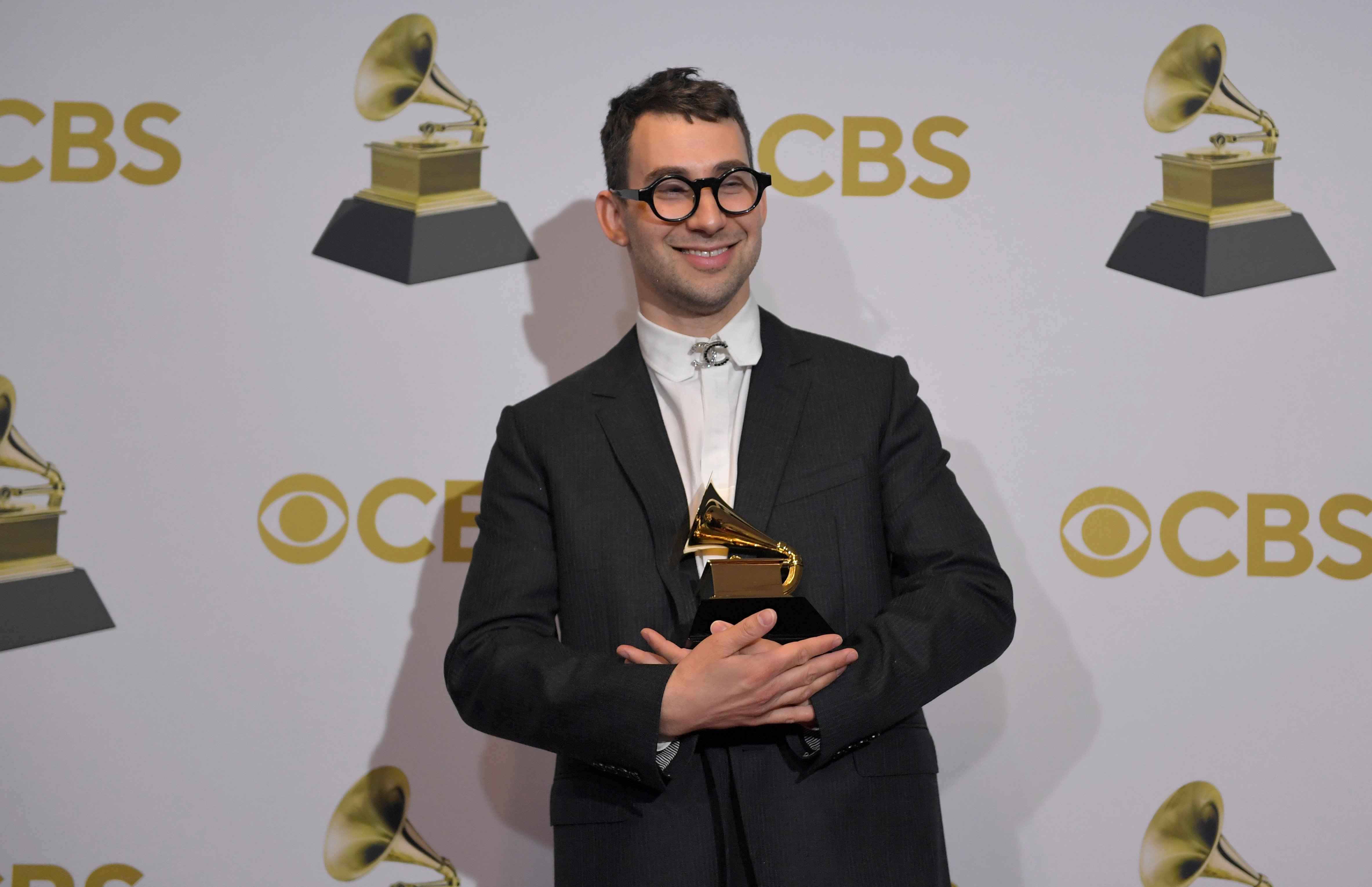 Jack Antonoff holds a Grammy Awards trophy in the winners photo room at the 2022 Grammy Awards