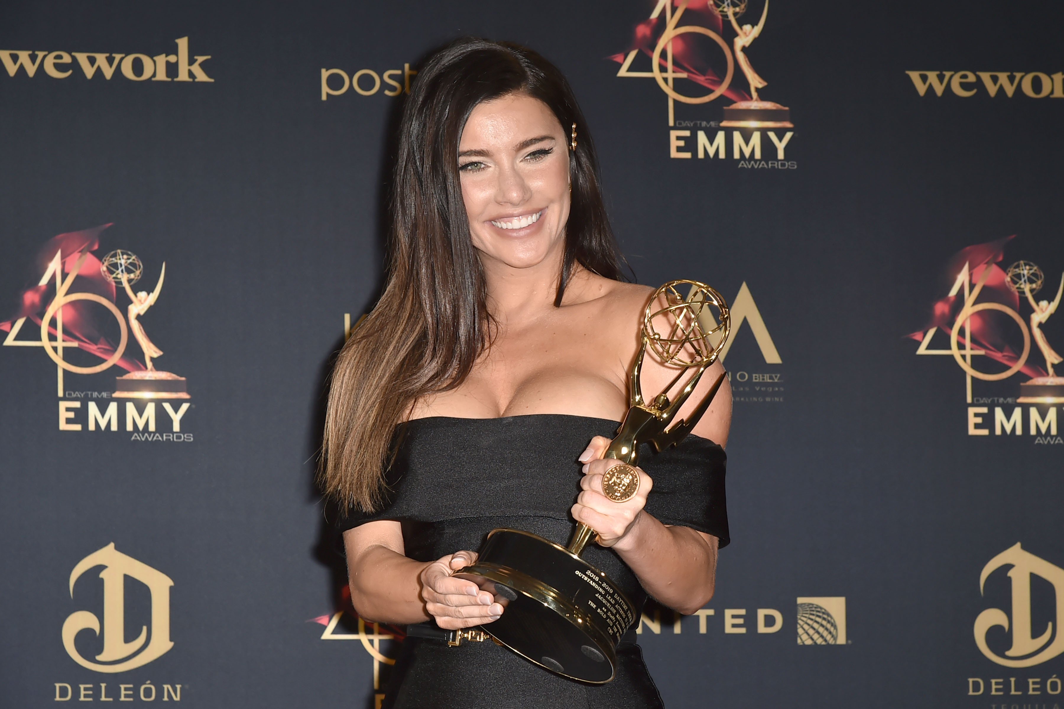'The Bold and the Beautiful' actor Jacqueline MacInnes Wood wearing a black dress and holding an Emmy.
