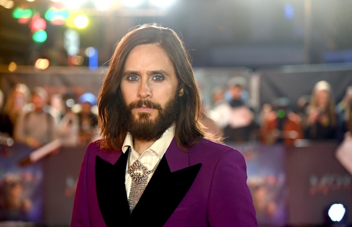 While wearing a purple suit coat and diamond tie, Jared Leto looks at the camera during the "Morbius" premiere in London
