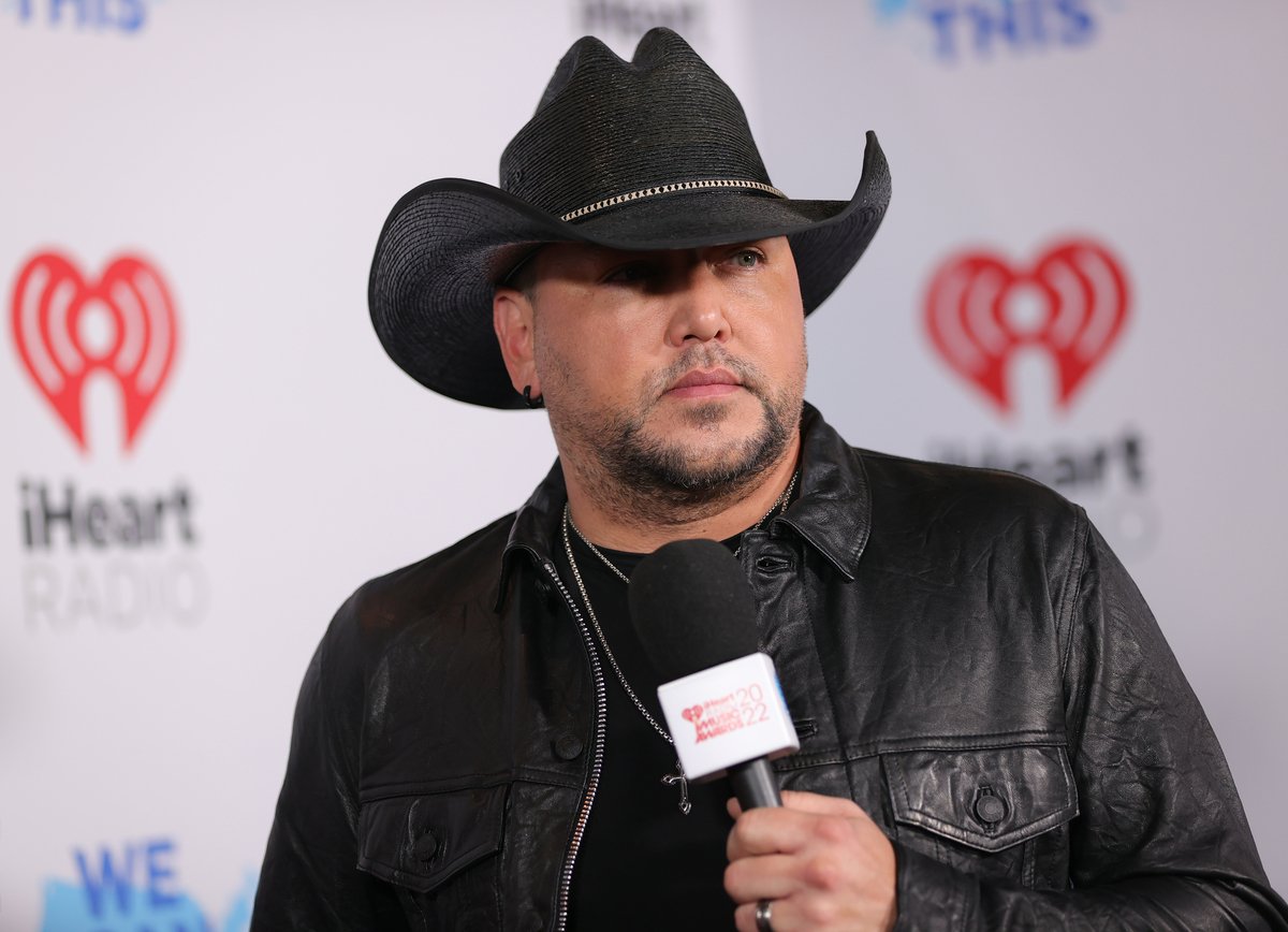 Wearing a black cowboy hat, Jason Aldean poses for photographers at the 2022 iHeartRadio Music Awards in LA.